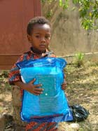 Enfant tenant une moustiquaire au Togo. Beaucoup de pays en
										manquent encore.